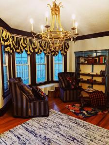 Magnolia LLC short term rentals private room on the second floor في Fergus Falls: غرفة معيشة مع كراسي جلدية وثريا