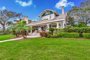 a house with a green roof and a lawn at Bayshore Charmer in Tampa