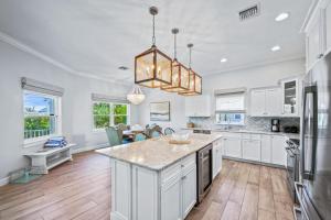 a kitchen with white cabinets and a large island at Spring Haven in Anna Maria