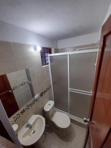 a bathroom with a toilet and a sink and a shower at Hostal la Lomita in Popayan