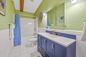a bathroom with a sink and a toilet and a mirror at Buttonwood Cottage in Anna Maria +38 photos