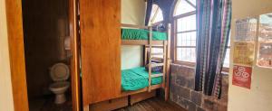 a room with a bunk bed with a toilet at Loki Cusco in Cusco
