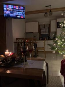 a living room with a table with wine glasses and a christmas tree at Domek przy Lubaniu in Ochotnica Dolna