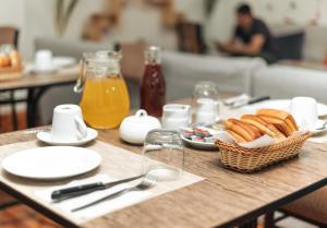 a table with a basket of bread and orange juice at Escobedo’s Inn Machupicchu in Machu Picchu