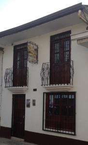 a white building with two doors and two balconies at Hostal la Lomita in Popayan