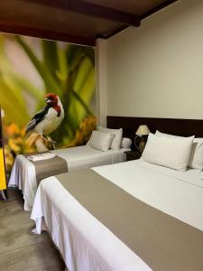 ein Vogel auf zwei Betten in einem Zimmer in der Unterkunft Pousada Castanho in Delmiro Gouveia