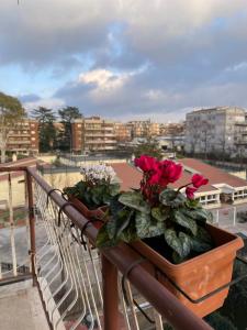 a balcony with flowers in a pot on a railing at Ilaria’s Apartment in Rome