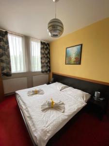 a bedroom with a white bed with two candles on it at Guest House Penzión Fortuna in Tvrdošín