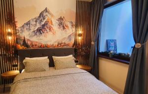 FOX boutique apartment Borovets Gardens في بوروفتس: غرفة نوم مع سرير مع لوحة جبلية على الحائط