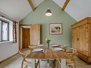 uma sala de jantar com uma mesa de madeira e cadeiras em 1 bed property in Lechlade 31912 em Lechlade