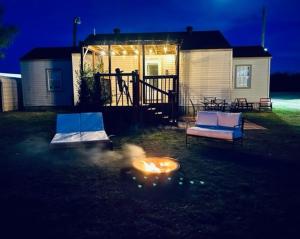 a fire pit in the yard of a house at night at Farm Charm in Iowa Park