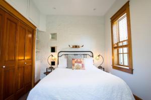 丹佛的住宿－The Grand Curtis，一间卧室配有一张带两盏灯的大型白色床。