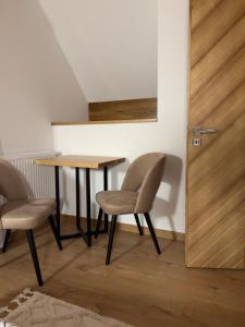 a table and two chairs in a room with a door at Domek przy Lubaniu in Ochotnica Dolna