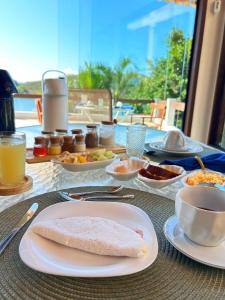 a table with a plate of food on a table at Oásis Beach House in Angra dos Reis