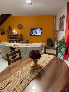 uma sala de estar com uma mesa de madeira e uma televisão em La Cigale Ardéchoise em Labégude