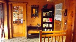 een houten kamer met een bank en een boekenplank bij Chalet Le Paradou in La Côte-dʼAime