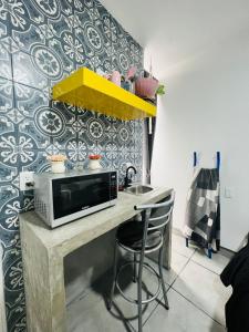 uma cozinha com um balcão com um micro-ondas e cadeiras em CASA AMBAR em Tijuana