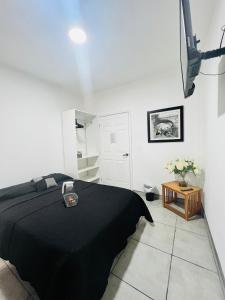 um quarto com uma cama preta num quarto branco em CASA AMBAR em Tijuana