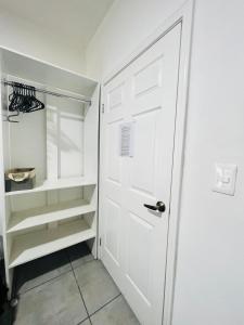 a white closet with a door and shelves at CASA AMBAR in Tijuana