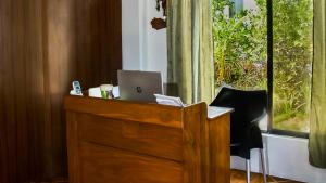 drewniane biurko z laptopem obok okna w obiekcie Penguin House w mieście Puerto Villamil