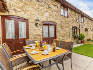 a wooden table with chairs on a patio at 3 bed in Bagillt 83813 in Bagillt