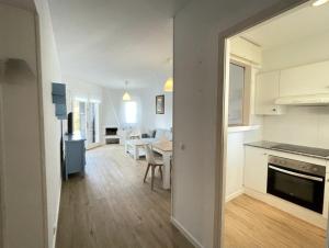 a kitchen and living room with a table and a dining room at Sa Posta in Cala en Forcat