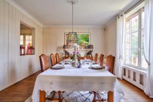 une salle à manger avec une table et des chaises blanches dans l'établissement Sublime family home in Versailles - Welkeys, à Versailles