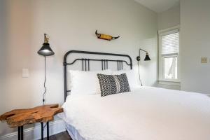 een slaapkamer met een wit bed en een houten tafel bij Radiant Rancher in Denver