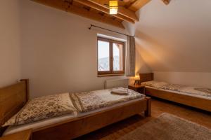 two beds in a room with a window at Drevenica Huty in Huty