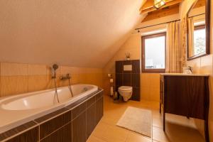 a bathroom with a large tub and a toilet at Drevenica Huty in Huty +27 photos