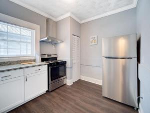 a kitchen with a stainless steel refrigerator and white cabinets at Modern Westshore in Tampa