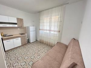 uma sala de estar com um sofá na cozinha em Aniva Apartments em Šušanj