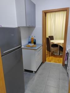 a kitchen with a refrigerator and a table at Apartman SM in Sremska Mitrovica