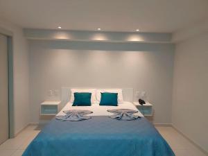 a bedroom with a blue bed with two green pillows at Flat Frente Mar - Praia de Tabatinga in Conde
