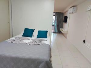 sypialnia z łóżkiem z niebieskimi poduszkami w obiekcie Flat Frente Mar - Praia de Tabatinga w mieście Conde