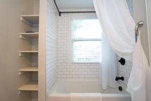 a white bathroom with a shower with a window at Pinky's Palace in Denver