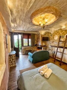 1 dormitorio con cama y pared de piedra en Anilia Guesthouse en Synikia Mesi Trikalon