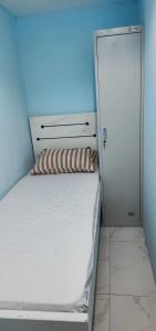 a small bedroom with a white bed and a door at Al Khaleez Accommodation in Dubai