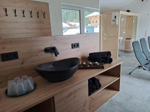 ein Badezimmer mit einem schwarzen Spülbecken auf einer Holztheke in der Unterkunft Zimmer & Appartements Schwarzenbacher Sonja & Konrad in Kleinarl