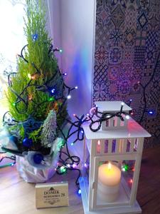 a small christmas tree and a candle next to a toy house at Domek Mordarka in Limanowa