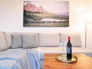 uma sala de estar com um sofá e uma garrafa de vinho na mesa em Fynbos City Penthouse, Dachterrasse, Design-Küche, Parkplatz em Straubing