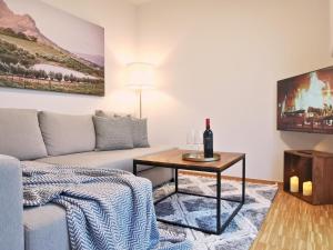 a living room with a couch and a table at Fynbos City Penthouse, Dachterrasse, Design-Küche, Parkplatz in Straubing