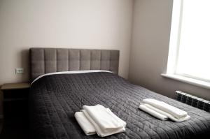 1 dormitorio con 1 cama con 2 toallas en Гостьовий Будинок Апартаменти в тихому центральному районі Полтави Смарт-квартири, en Poltava