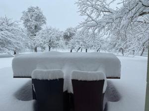 un banco cubierto de nieve con nieve. en Ferienwohnung in Aistersheim 