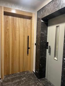 a bathroom with a wooden door and a elevator at Résidence Escalade 1 in El Jadida