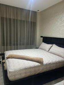 - une chambre avec un grand lit et une fenêtre dans l'établissement Résidence BAYTI, à El Jadida