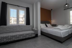 a bedroom with a bed and a couch and a window at LA CASA DE PROFESOR 5 in Kalabaka
