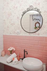 uma casa de banho rosa com um lavatório e um espelho em Vrnjačka Romansa Studio - Pešačka zona - Ravni deo - Baby friendly em Vrnjačka Banja