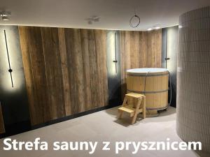 a room with a barrel and a wooden wall at Zakątek Śniardwy in Nowe Guty