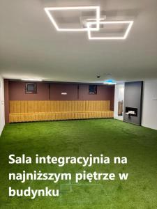 um quarto amplo com piso alcatifado verde num edifício em Zakątek Śniardwy em Nowe Guty
